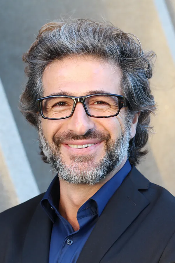 Andropause-and-Low-Testosterone-Treatment A man with glasses, salt and pepper hair and a beard smiling because he received treatment for andropause and low testosterone from AZENA Health & Longevity in Gainesville.