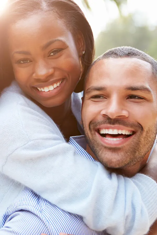 Erectile-Dysfunction-Treatment A woman riding on a man's back, both smiling due to help with erectile dysfunction from AZENA Health & Longevity in Gainesville.