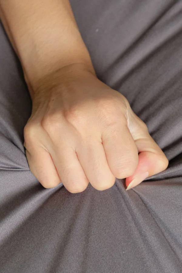 Female-Sexual-Dysfunction-Treatment Close-up of a woman's hand grabbing a sheet, indicating sexual pleasure. Get female sexual dysfunction treatment from AZENA Health & Longevity in Gainesville.
