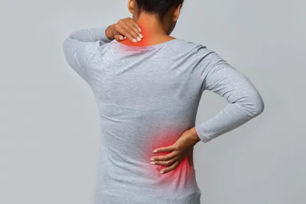 Fibromyalgia-Clinic An image from behind of a woman suffering from Fibromyalgia holding her hands on her neck and lower back. Get fibromyalgia care from AZENA Health & Longevity in Gainesville.