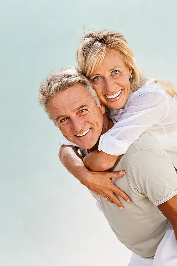 Food-Allergies-Treatment-1 A happy mature couple having fun - the husband is carrying his wife on his back. Get treatment for food allergies from AZENA Health & Longevity in Gainesville.