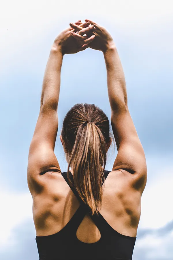 GLP-1-Weight-Loss-Injections-Treatment Back view of a woman stretching toward the sky, symbolizing empowerment and body transformation through GLP-1 weight loss treatments by AZENA Health & Longevity in Gainesville.