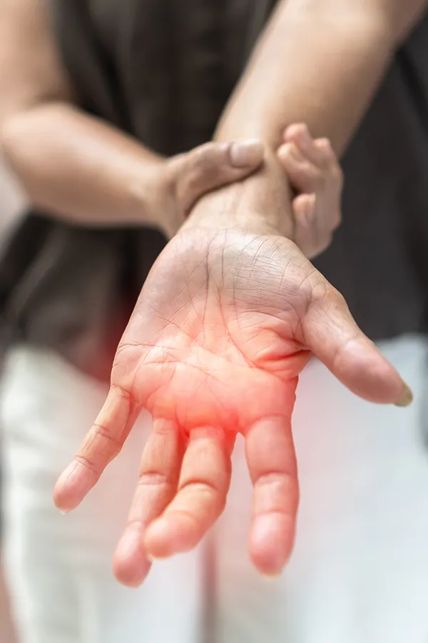 Neuropathy-and-Nerve-Pain-Treatment A woman holds her wrist with nerve pain. Get Neuropathy and Nerve Pain Treatment from AZENA Health & Longevity in Gainesville.