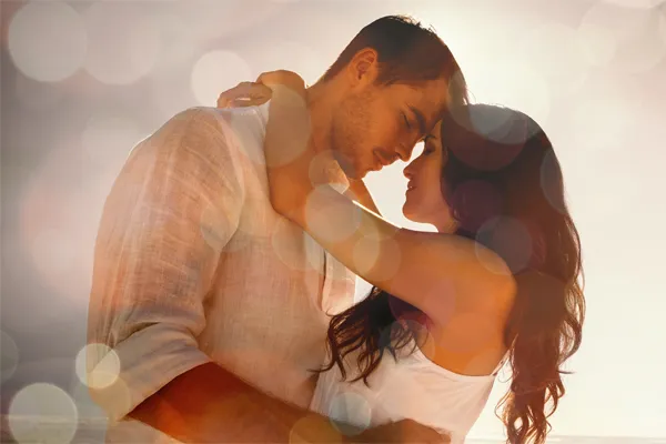 Sexual-Wellness-for-Women-and-Men-Doctor A couple in linen shirts standing in a sparkling light embraces each other with their foreheads touching and eyes closed, happy with their sexual wellness treatments from AZENA Health & Longevity in Gainesville.